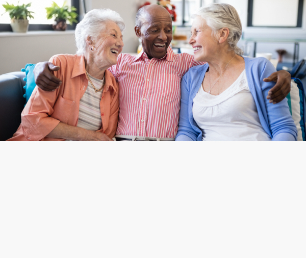 Three residents laughing together in a common area.