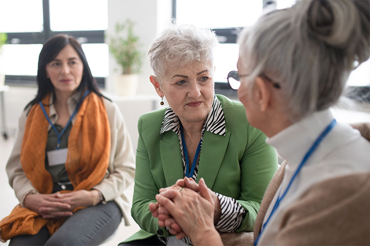 Three elderly women engaging in conversation