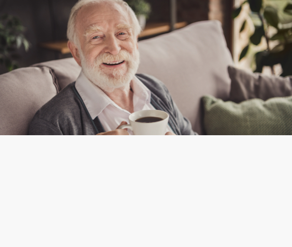 Smiling senior man enjoying coffee on a sofa