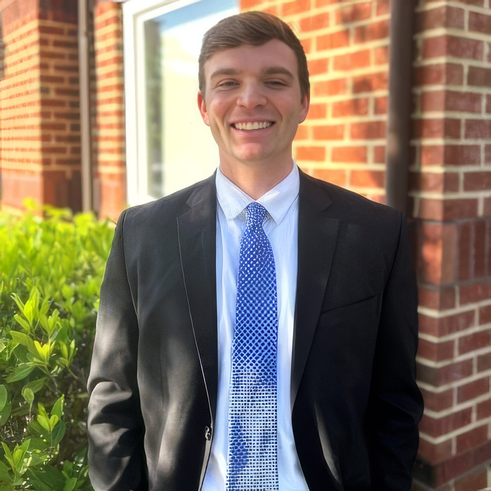 Smiling man in a suit outside a facility