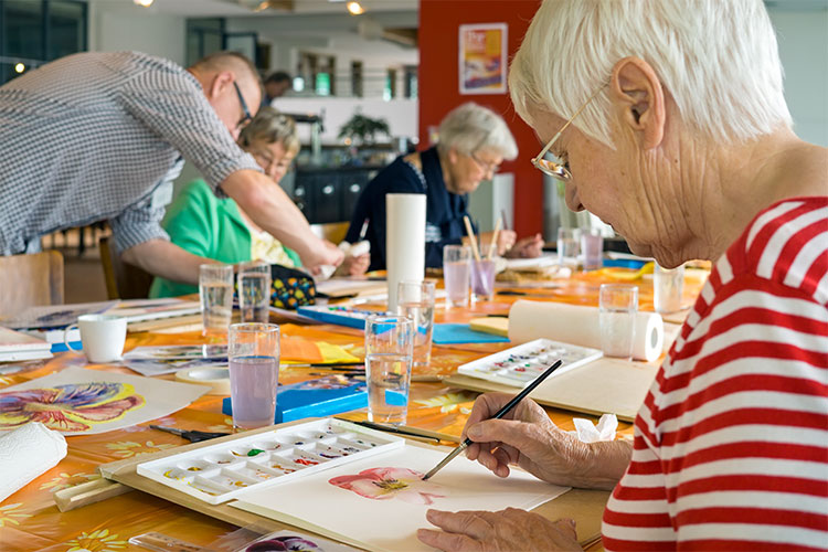 Residents engaged in art activity at a table