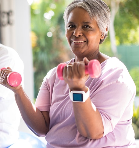 Senior woman exercising with pink weights