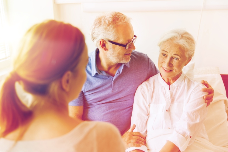Staff engaging with two elderly residents in a room
