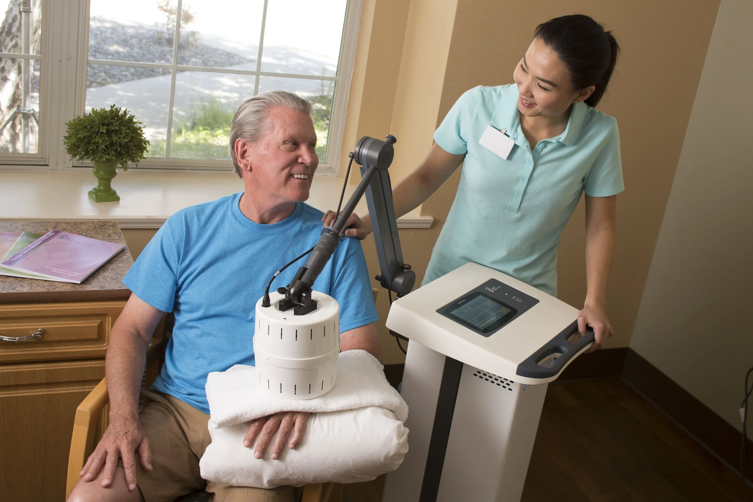 Staff assisting a resident with therapy equipment.
