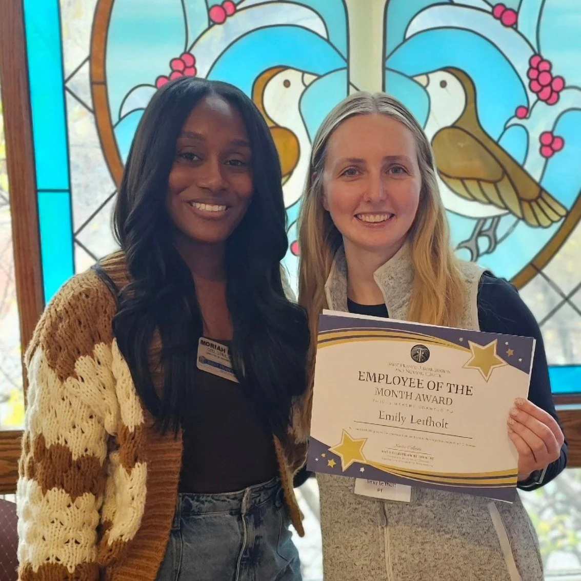 Two staff members celebrating an award presentation.