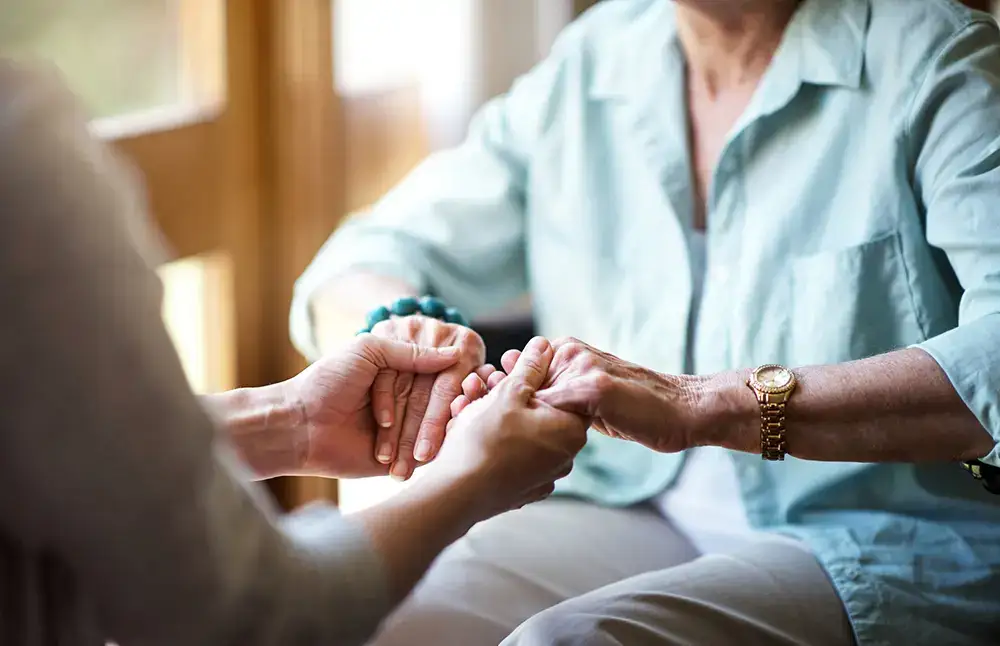 Care staff holding hands with a resident
