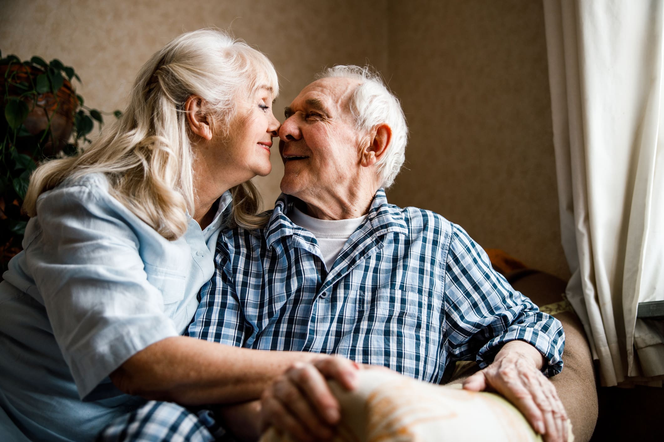 Elderly couple sharing a tender moment indoors