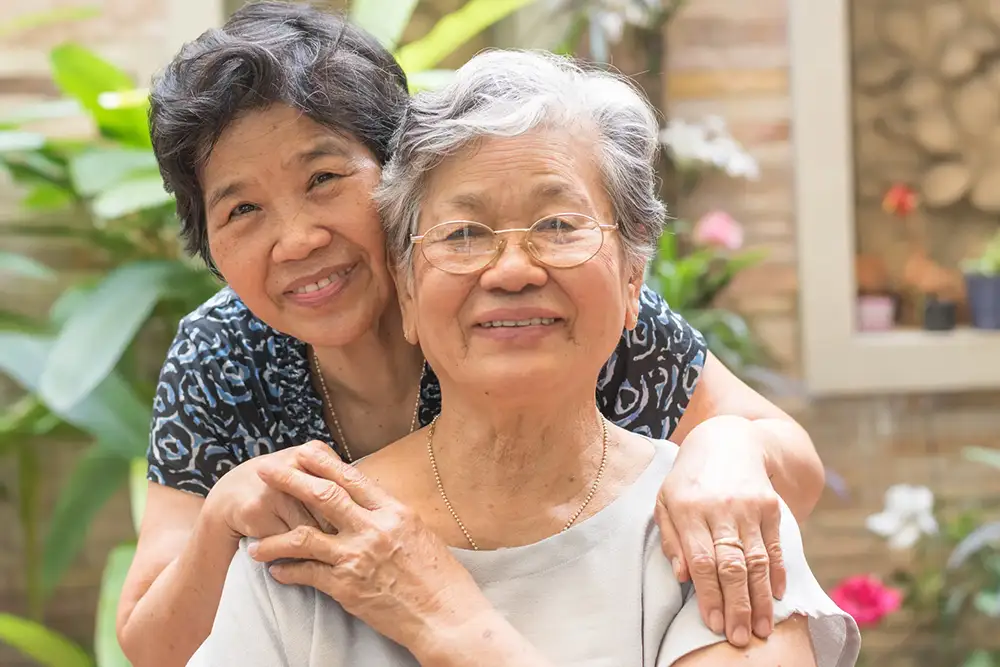 Two smiling women in a garden setting
