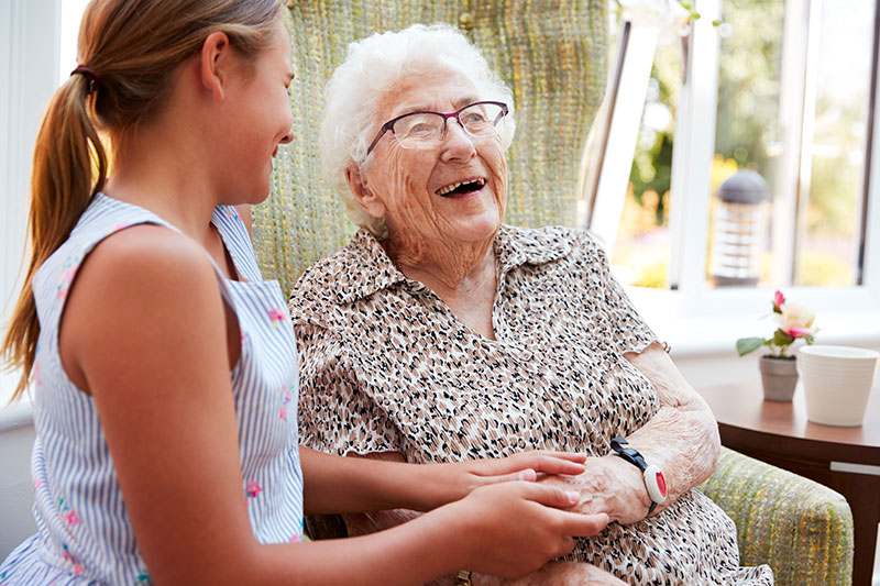 Elderly woman laughing with a young girl