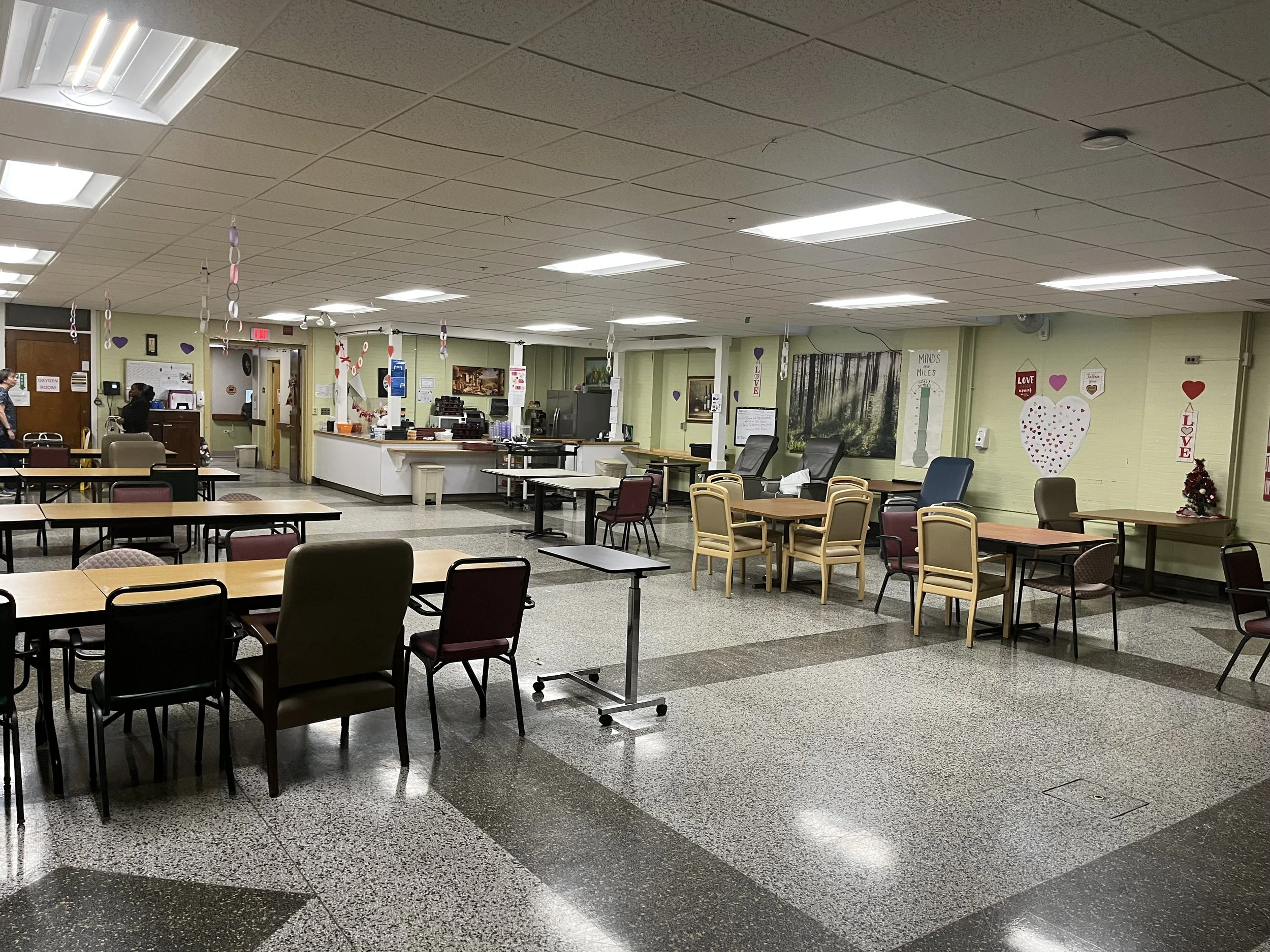 Interior view of a common area with tables and chairs.