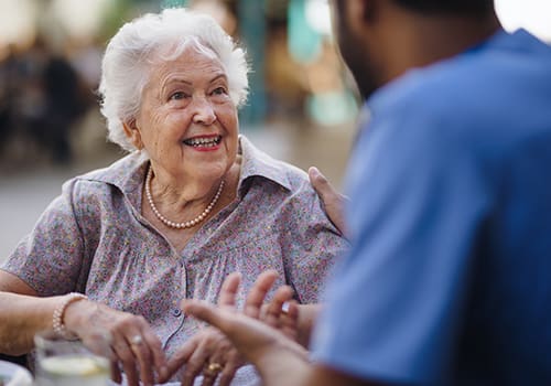 Elderly woman smiling and engaged in conversation