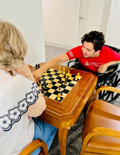 Resident playing chess with a staff member.