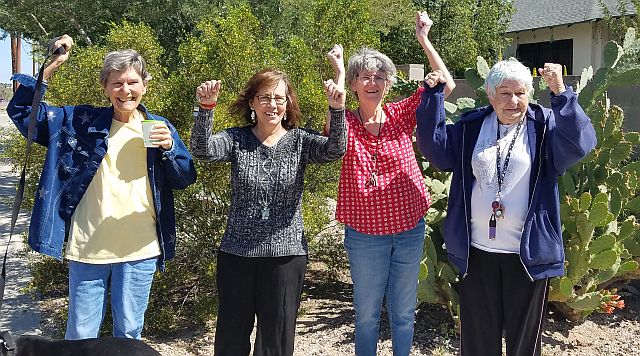 Four residents cheerfully posing outdoors.