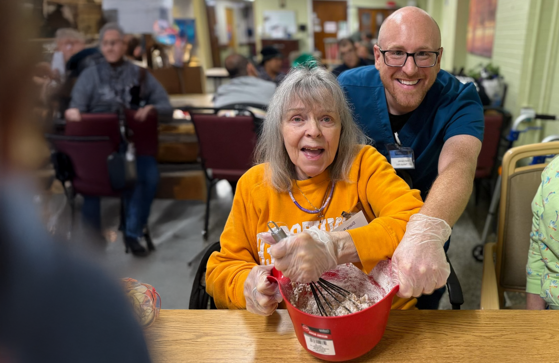 Resident and staff member enjoying a cooking activity.