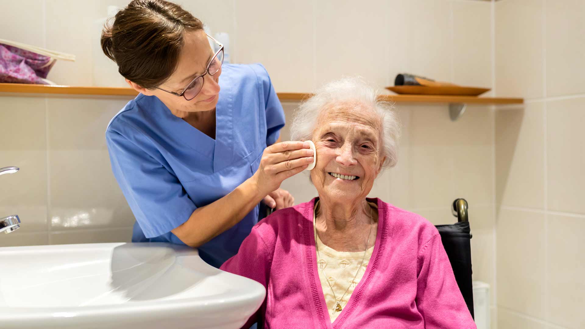 Caregiver assisting a smiling elderly resident