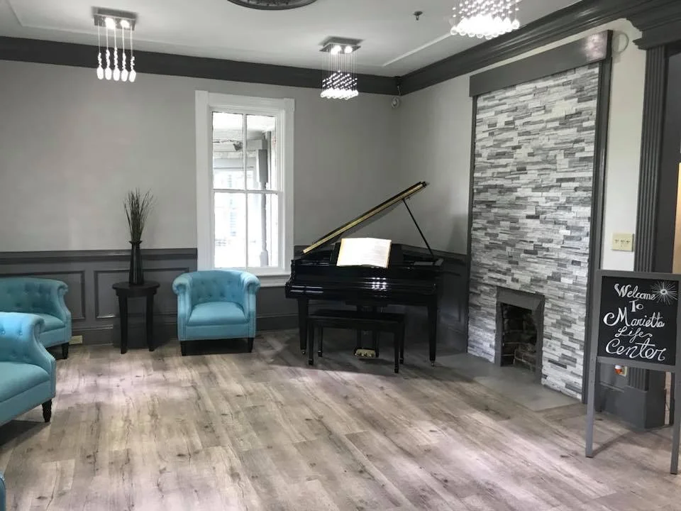 Interior common area with piano and seating.