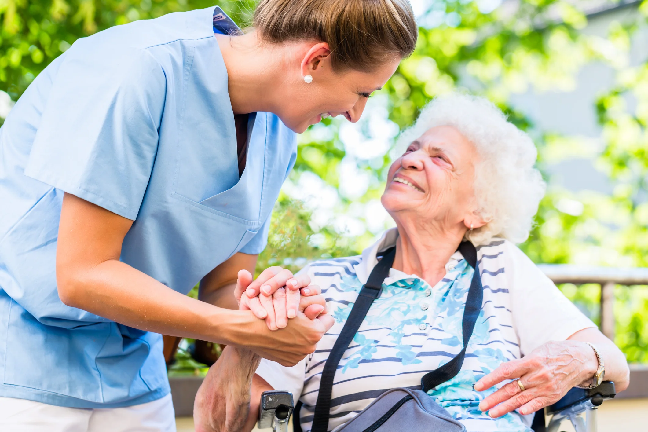 Care staff interacting with an elderly resident outdoors