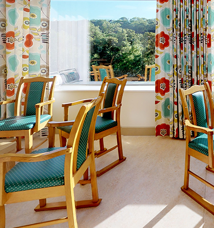 Bright interior space with wooden chairs and floral curtains.