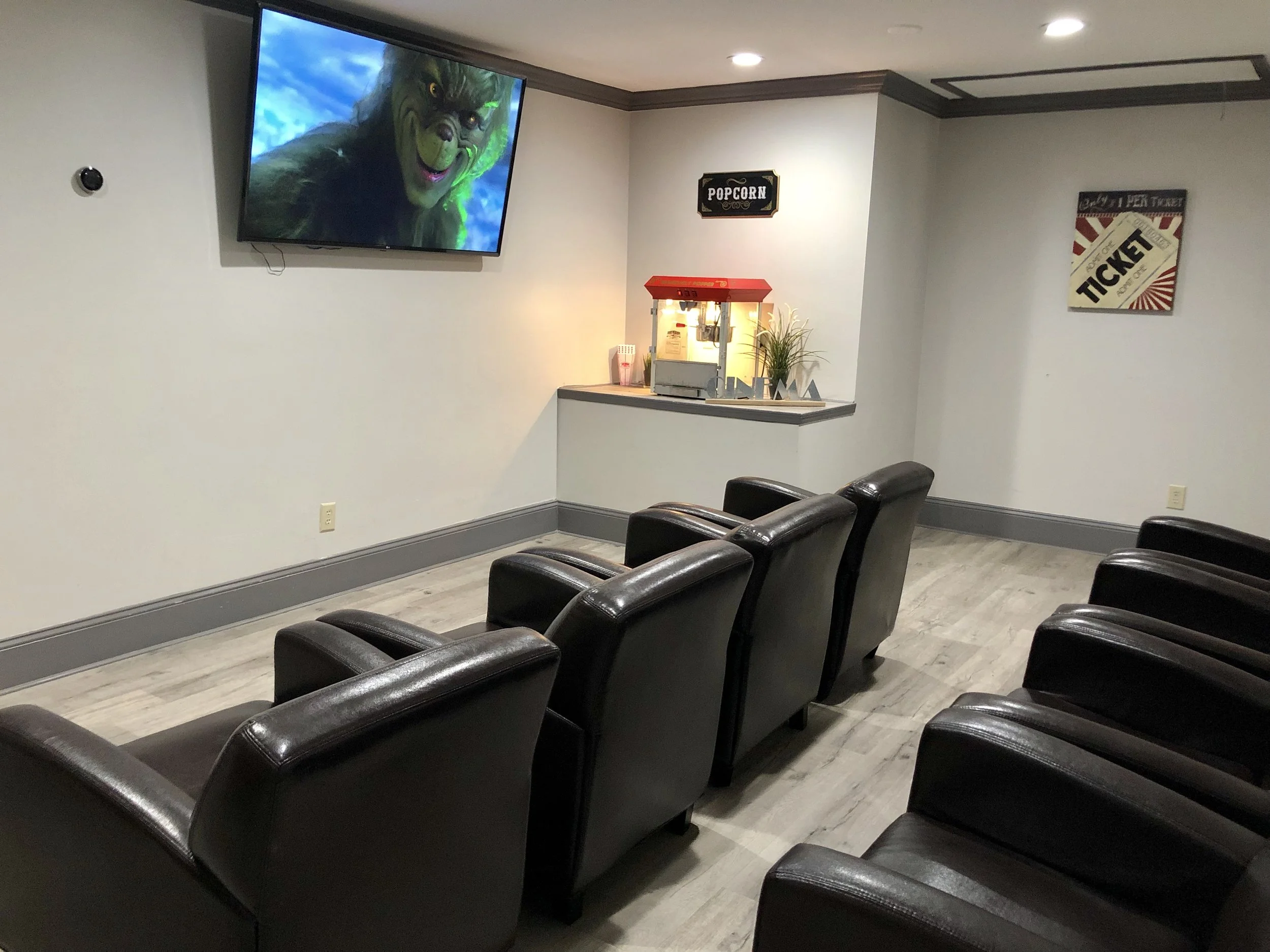 Seating area with a movie screen and popcorn machine.