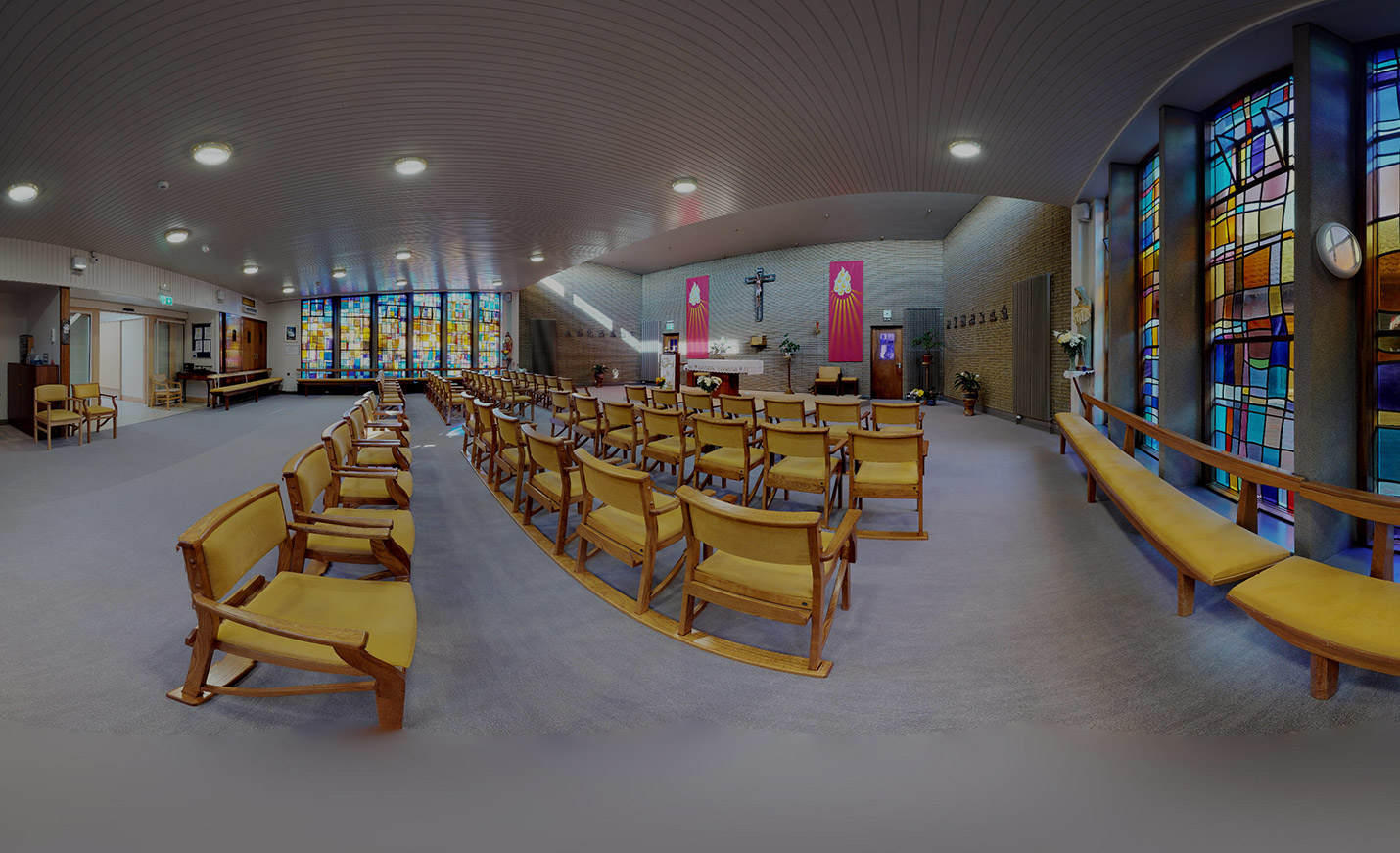 Interior view of a serene common area with chairs and stained glass.