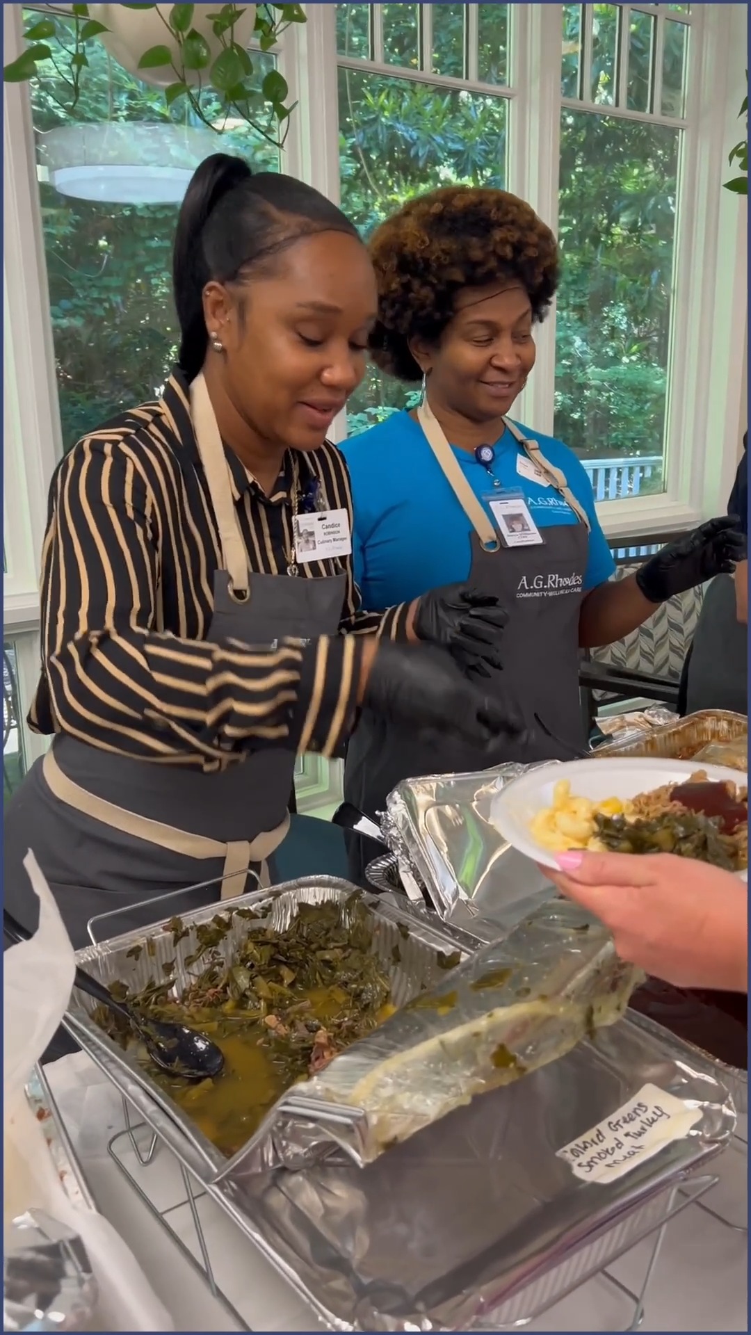 Staff serving food to residents in a common area.
