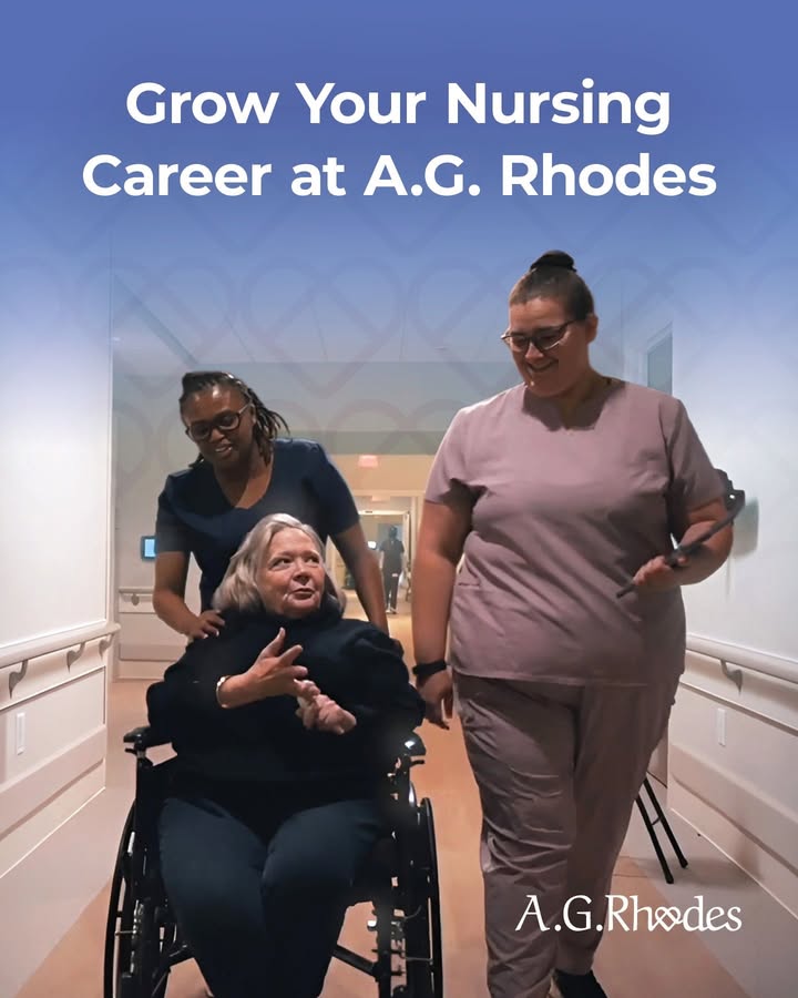 Staff assisting a resident in a hallway.