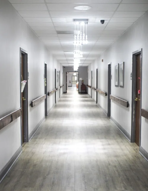 A well-lit hallway in a nursing home facility.