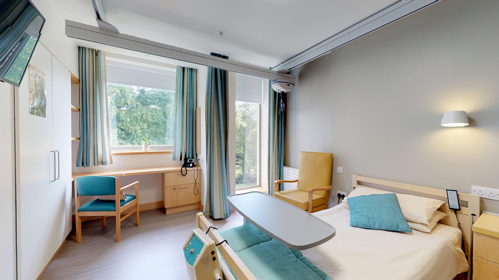 A comfortable resident room with a bed and chair.