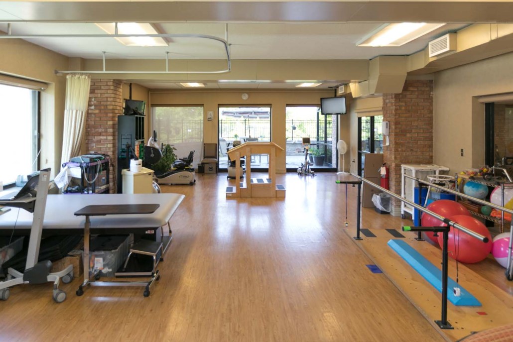 Rehabilitation gym with various exercise equipment.