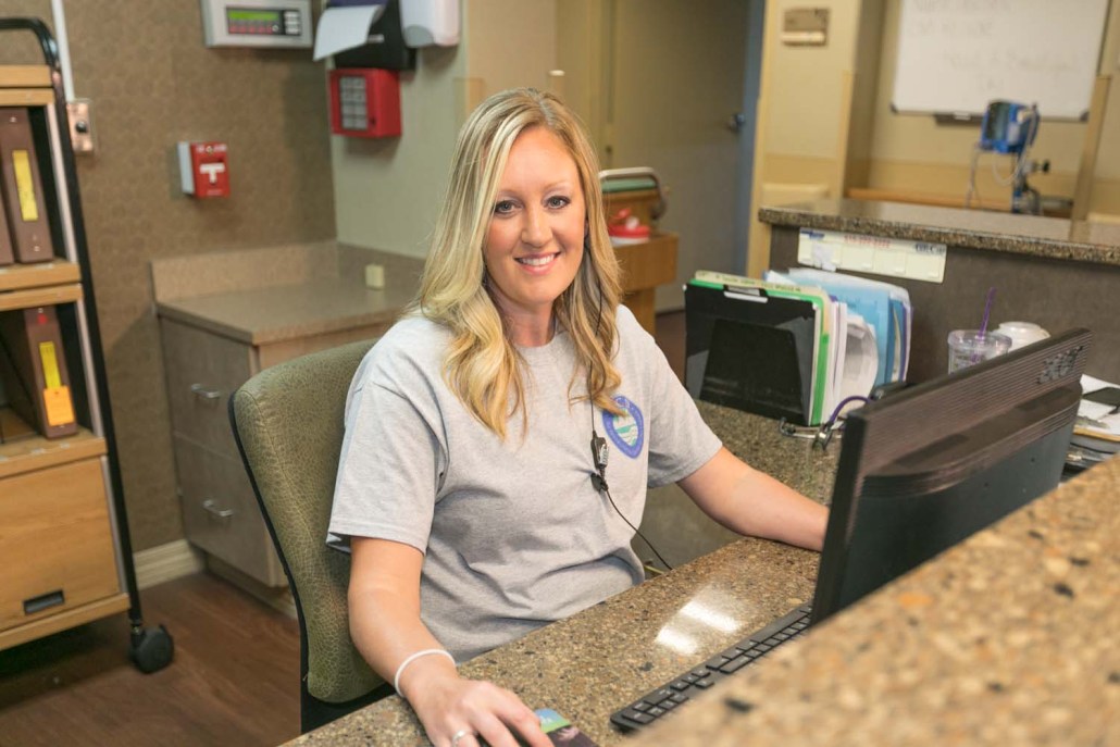 Staff member at the reception desk, assisting residents.