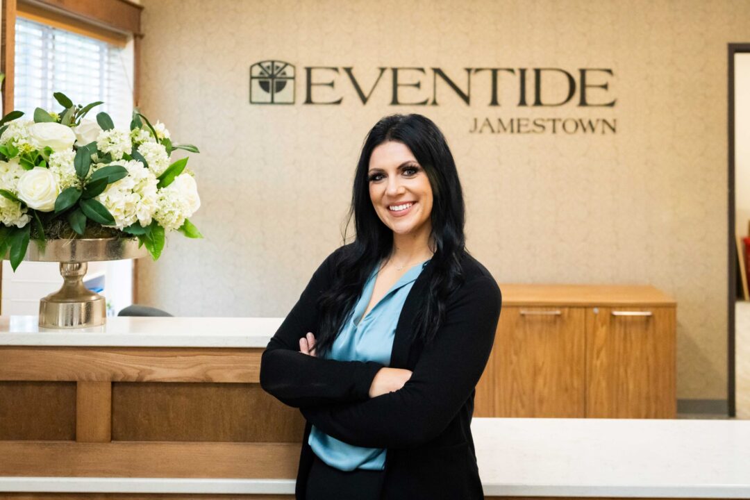 Staff member at reception with floral arrangement