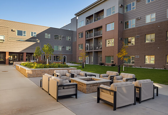 Outdoor seating area with fire pit and landscaping.