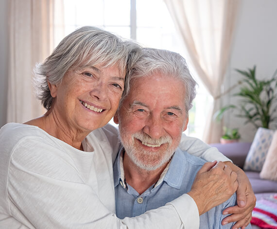 Happy senior couple smiling together indoors.