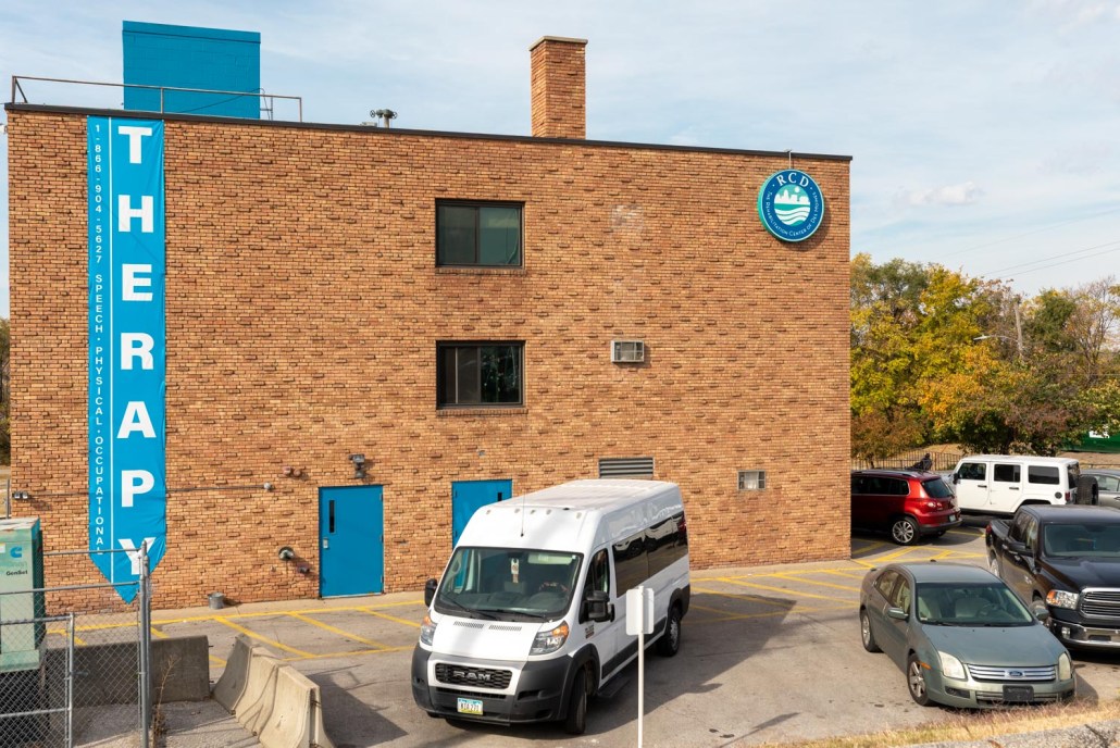 Exterior view of the therapy building with a transport van