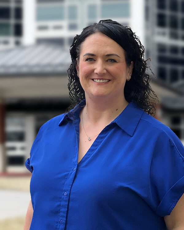 Staff member posing outside the facility building.