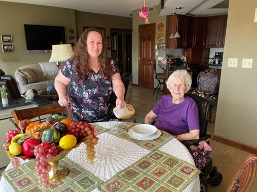 Staff assisting a resident at a dining table.