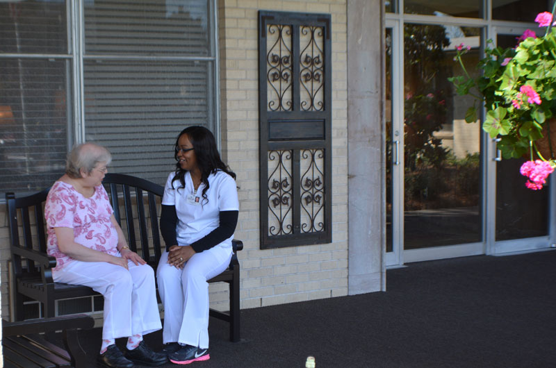 Resident and staff member chatting outside