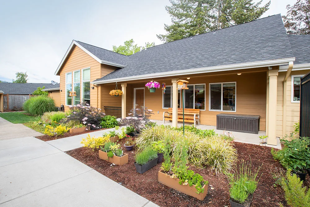 Front entrance of a residential facility with landscaped gardens.