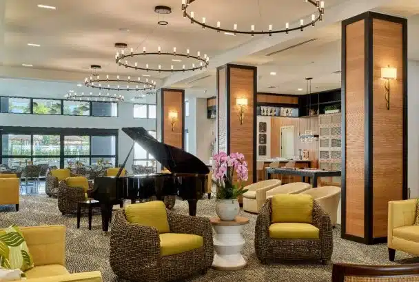 A bright and welcoming common area with seating and a piano.