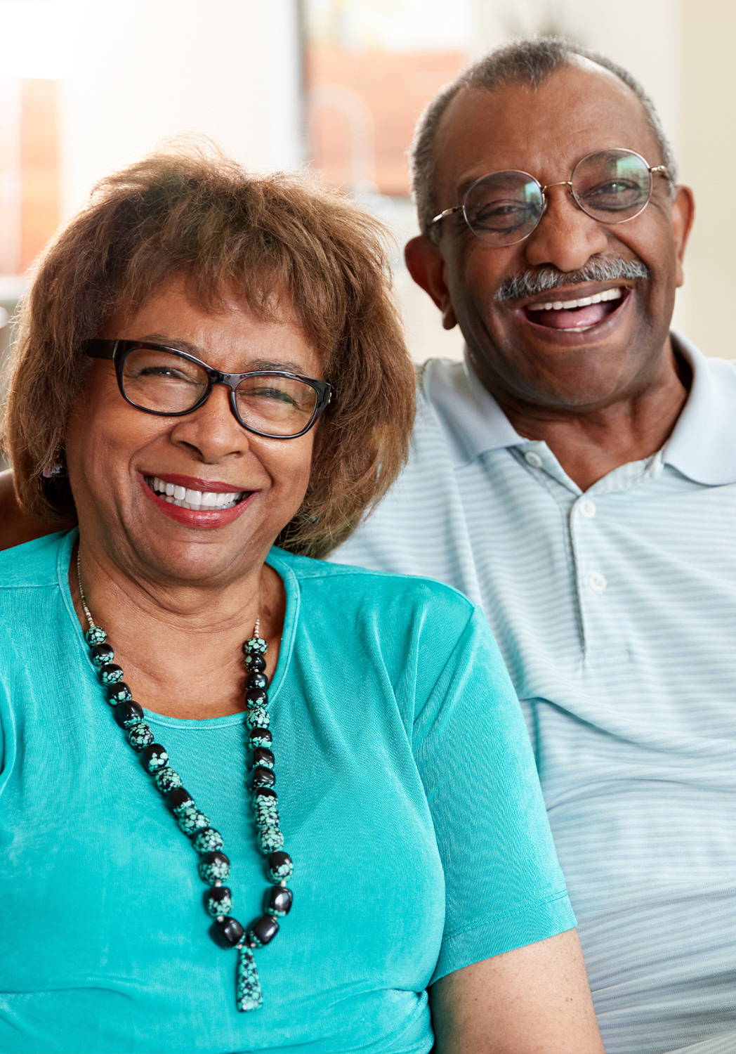 A smiling elderly couple posing together.