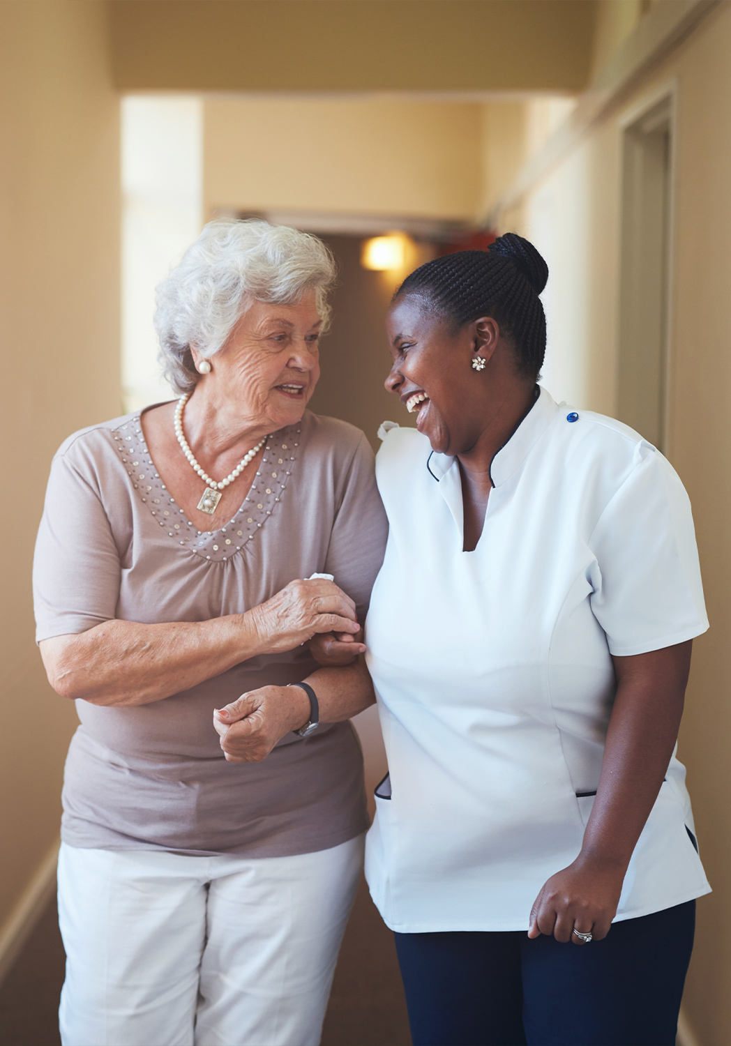Senior resident and staff member laughing together