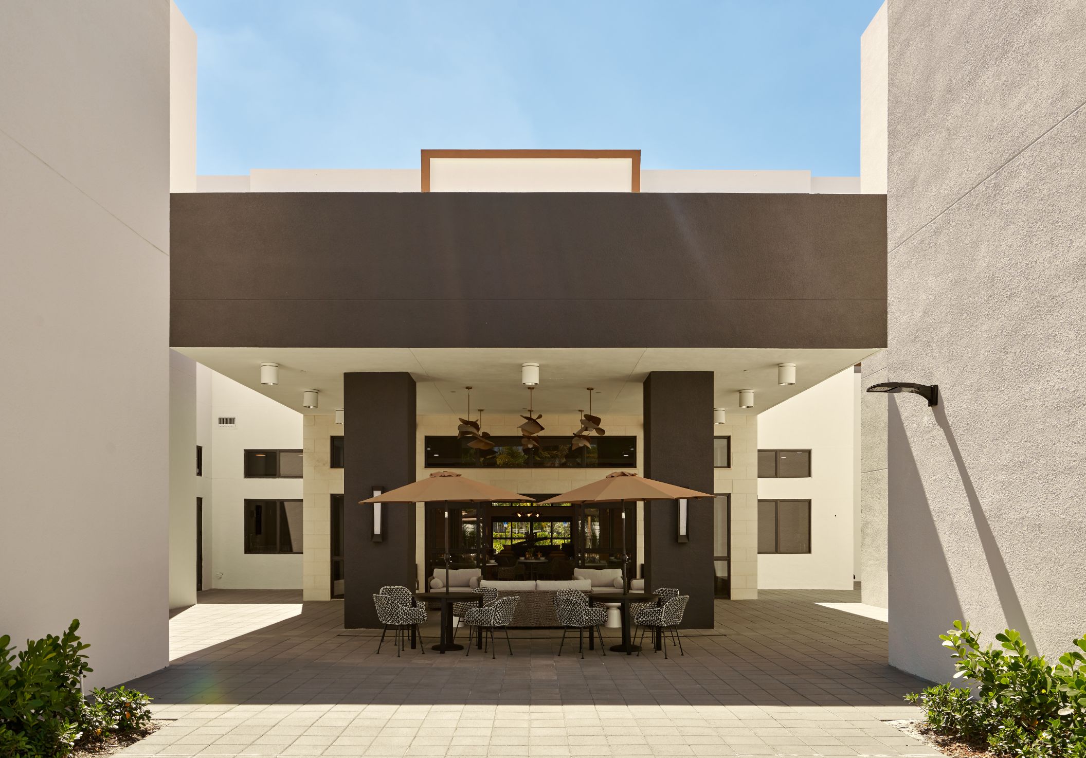 Outdoor seating area with umbrellas and tables.