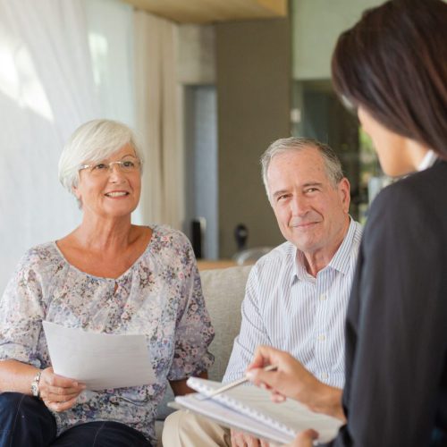 Residents engaged in conversation with staff in a common area