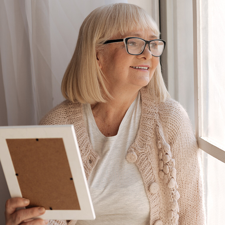 A smiling senior woman looking out the window