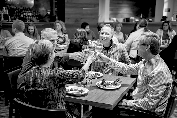 Residents enjoying a meal and cheers at a dining table