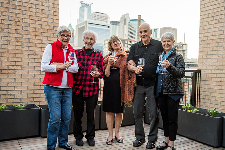 Residents celebrating with drinks on a balcony