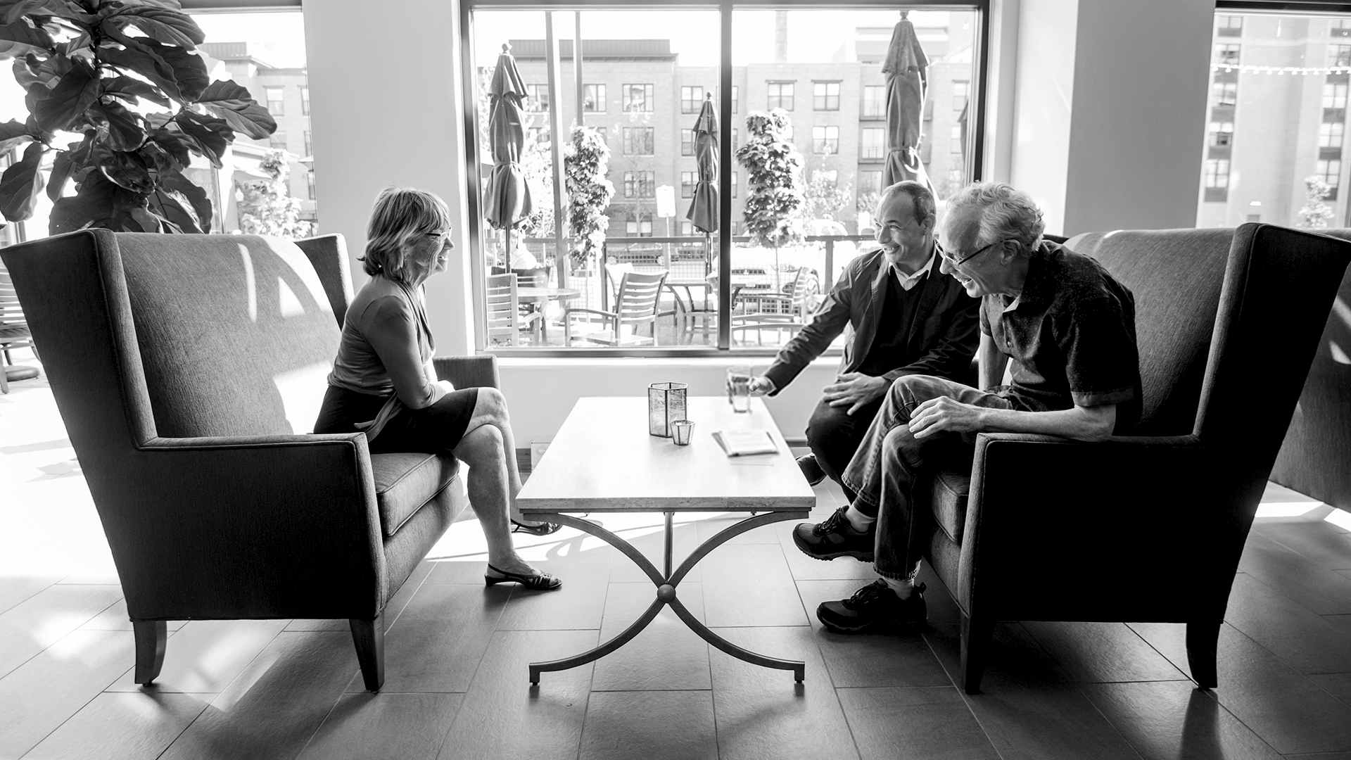 Residents and staff in a common area discussing at a table
