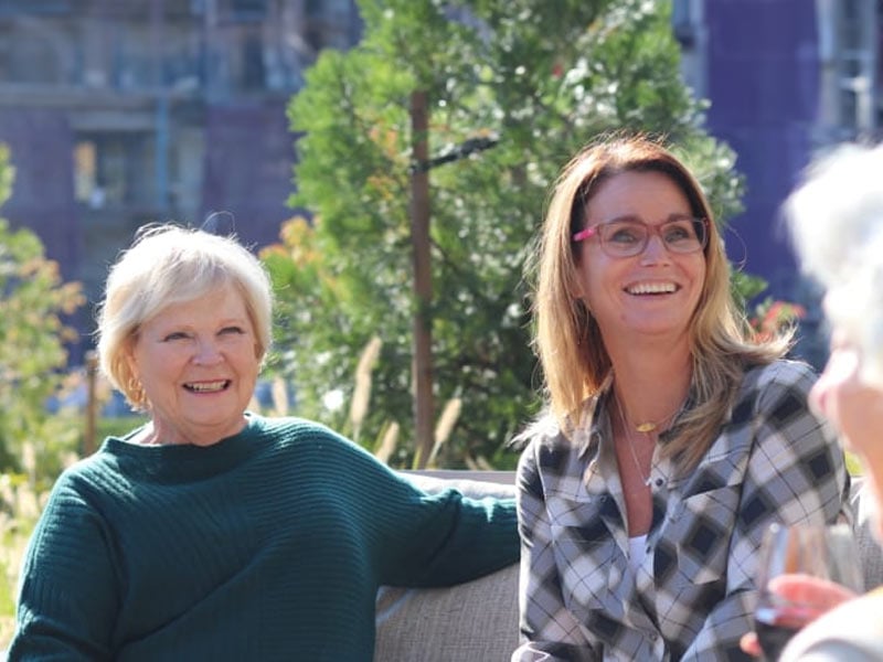 Two women laughing in an outdoor space