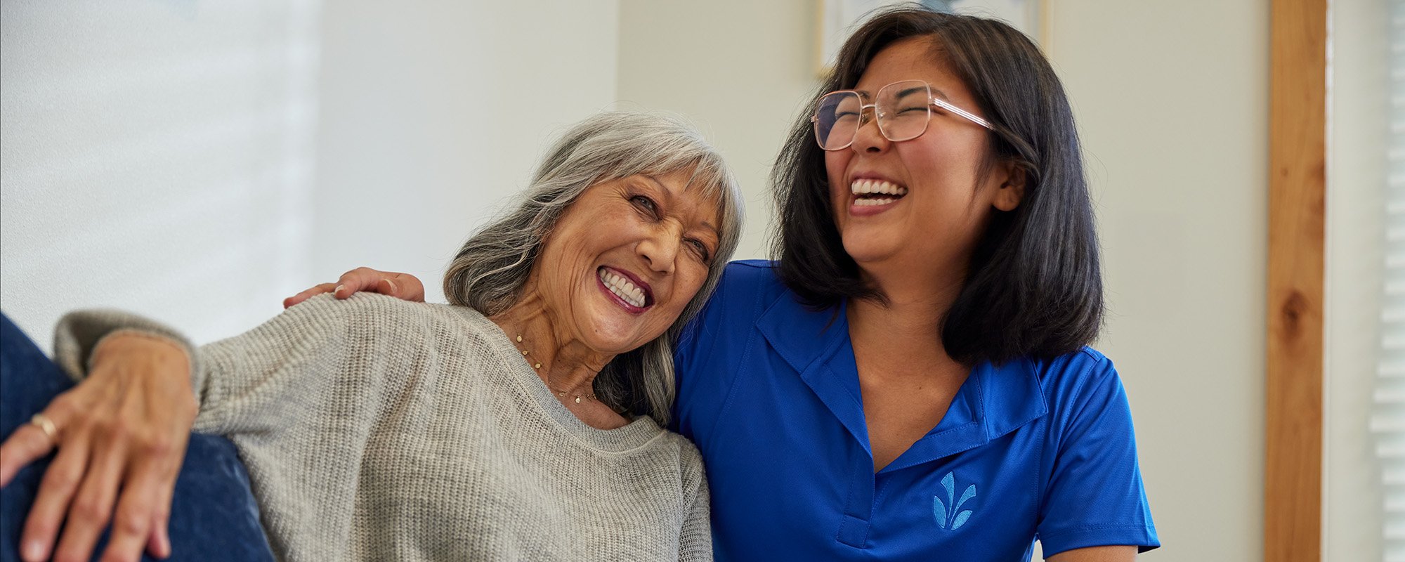 Caregiver and resident laughing together indoors