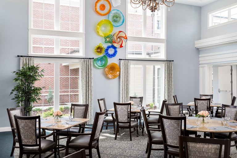 Bright dining room with decorative wall art and tables set for meals